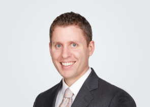 Headshot of David Seymour, a man with blond-brown hair, in front of a light grey background.