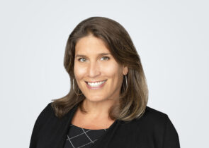 Headshot of Dawn Taffler, a woman with blond-brown hair, in front of a light grey background.