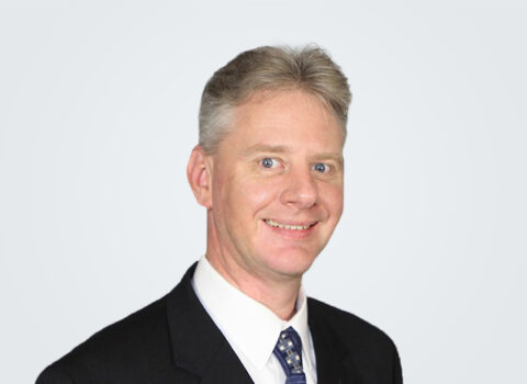 Headshot of Jeremie Maehr, a man with blond-grey hair, in front of a light grey background.