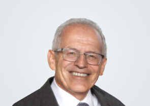 Headshot of Steven Frey, a man with white hair, in front of a light grey background.