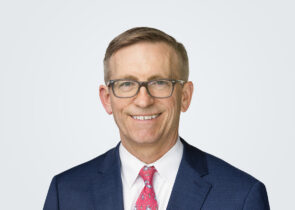 Headshot of Todd Reynolds, a man with blond hair, in front of a light grey background.