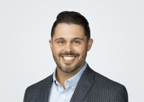 Headshot of Spencer Archer, a man with dark brown hair, in front of a light grey background.