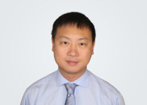 Headshot of Xiangquan Li, a man with dark brown hair, in front of a light grey background.