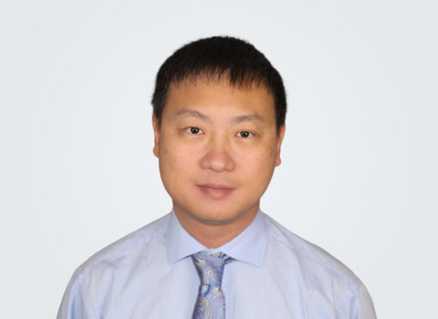 Headshot of Xiangquan Li, a man with dark brown hair, in front of a light grey background.
