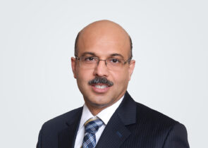 Headshot of Lakshya Sobti, a person with short dark hair, wearing a suit with a blue plaid tie.